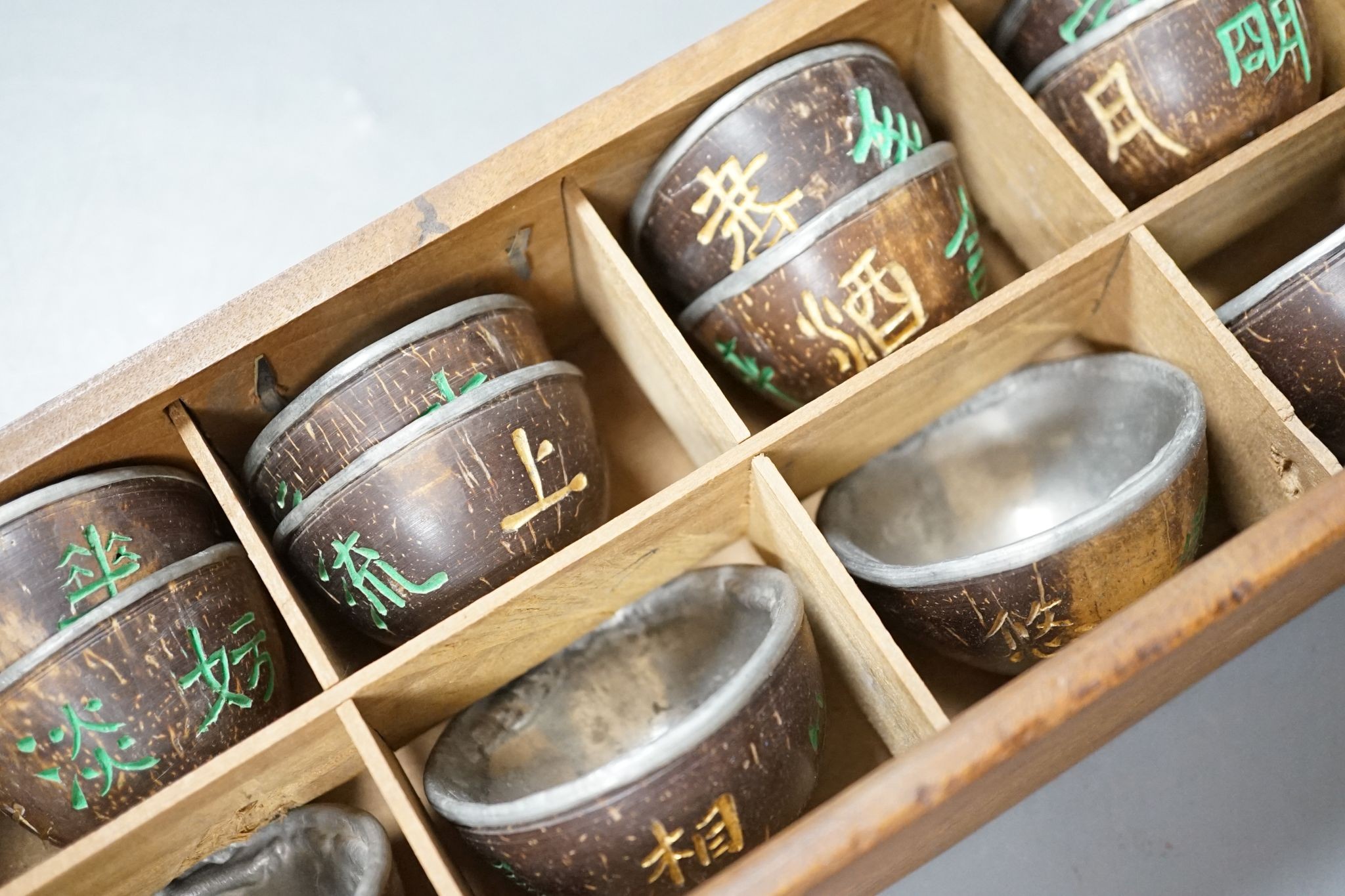 An early 20th century Chinese cased set of coconut cups with pewter liners